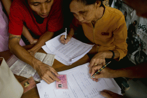 UPDATING VOTER ROLLS  This photo taken on June 29, 2015 shows a member of the National League for Democracy (NLD) checking voter lists during a door-to-door visit for a voter education campaign in Yangon. AFP PHOTO