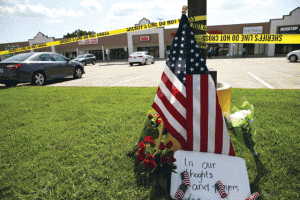 SHOOTING IN TENNESSEE Police tape and a makeshift memorial frame the scene at an Armed Forces Career Center July 16, 2015 in Chattanooga, Tennessee, where earlier in the day an active shooter opened fire, injuring one US Marine. The gunman later moved to the nearby Navy Operational Support Center (NOSC) firing multiple shots, killing four Marines and injuring one Sailor. AFP PHOTO