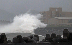 RAINCOAT WEATHER  Giant waves crash into the coastline next to National Taiwan Ocean University (R) in Keelung as Typhoon Chan-hom brings rain to northern Taiwan on July 10, 2015. Taiwan was bracing for fierce winds and torrential rains on July 10 as Typhoon Chan-hom gained momentum and the island’s stock market, schools and offices closed in preparation for the storm. AFP PHOTO