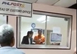 GOTCHA A grab from a camera phone video posted on Facebook purportedly shows Customs inspectors at the post office rummaging through a parcel. CONTRIBUTED PHOTO 