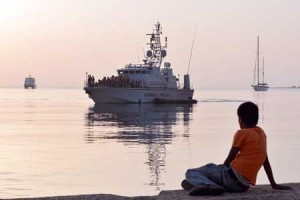 NEW ARRIVALS  A migrant boy watches an Italian Frontex vessel loaded by intercepted migrants arriving to the port of Kos on August 16, on the island of Kos. Authorities on the island of Kos have been so overwhelmed that the government sent a ferry to serve as a temporary center to issue travel documents to Syrian refugees -- among some 7,000 migrants stranded on the island of about 30,000 people. AFP PHOTO