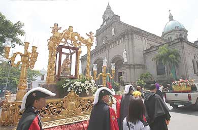 The carriage bearing the replica image of the Santo Niño de Cebu passes the Manila Cathedral as it makes its way to San Agustin church on Thursday. PHOTO BY RENE DILAN