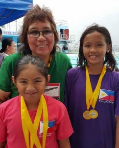 Record-breakers Micaela Jasmine Mojdeh of Immaculate Heart of Mary College-Paranaque and Isis Arnaldo of St. Agnes Academy pose with Philippine Swimming League President Susan Papa. CONTRIBUTED PHOTO