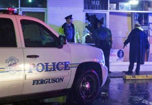 EMOTIONS RUNNING HIGH  Police officers survey the damage after a local business was burglarized and looted during a protest march on West Florissant Avenue in Ferguson, Missouri on August 9. A day of peaceful remembrance marking the anniversary of 18-year-old black teen Michael Brown’s killing by police in the US city of Ferguson came to a violent end on August 9 as gunfire left at least one protester injured. AFP PHOTO