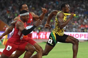 Jamaica’s Usain Bolt (R) races away with the baton from US’ Mike Rodgers (left) after US’ Tyson Gay (center) handed off to him in the final of the men’s  4x100m relay athletics event  at the 2015 IAAF World Championships at the “Bird’s Nest” National  Stadium in Beijing.  AFP PHOTO 