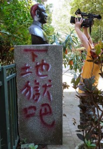 STATUE ABUSE This picture taken on August 27, 2014 shows a man filming a statue of the late nationalist leader Chiang Kai-shek that has been vandalized with paint and reads, “go to hell” in the northern city of Keelung. One has been beheaded, others defaced. Pranksters dress some in costumes. Statues of Taiwan’s former ruler Chiang Kai-shek have been increasingly targeted as the island confronts its authoritarian past. AFP PHOTO 
