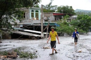 CLOUDY WITH A CHANCE OF MUD  This picture taken on August 1, 2015 shows residents walking past homes inundated in thick mud in a community located next to the Mong Duong coalmine following heavy rains in the northern coastal province of Quang Ninh. Quang Ninh was last week hit by the heaviest rain recorded in 40 years, with up to 800 millimeters in some areas causing flooding, landslides and toxic sludge spills from coalmines.  AFP PHOTO