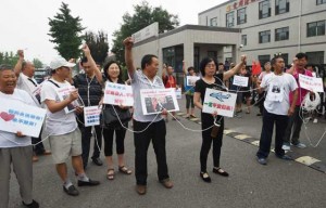 DEMANDING ANSWERS  Relatives of passengers on missing Malaysia Airlines MH370, who tied themselves together so they couldn’t be separated by police, chant slogans while waiting for an expected meeting with Malaysian officials, outside an office on the outskirts of Beijing on August 7. AFP PHOTO