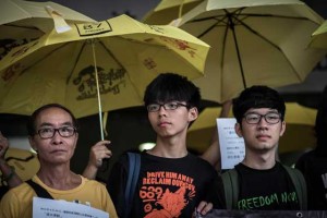 LEGAL HASSLE  Student protesters Joshua Wong(center L) and Nathan Law (R) stand outside the court of justice in Hong Kong on August 28. Wong appeared in court over an anti-China protest in June 2014, a day after he faced fresh charges over his participation in the 2014 pro-democracy Occupy movement. AFP PHOTO