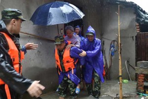 SAVED FROM THE DELUGE  Rescuers carry an elderly lady (C) out of her flooded home as Typhoon Soudelor brought heavy rain to Ningde, eastern China’s Fujian province on August 9. A weakened Typhoon Soudelor made landfall in China and was set to be downgraded, according to the National Meteorological Center, after the storm killed six people in Taiwan.  AFP PHOTO