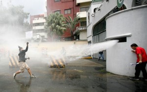 WATER BOMBED A member of the League of Filipino Students is met with a water cannon as he attempts to hurl a paint bomb at the gate of Camp Aguinaldo in Quezon City. A group of young people held a rally to protest alleged military killings of lumad in Mindanao. PHOTO BY MIGUEL DE GUZMAN 