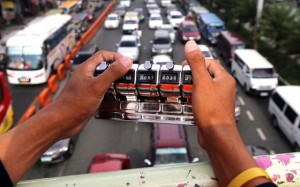 ROAD CONTROLLER  A Public Works personnel uses a click counter to count the number of vehicles passing through a chokepoint on Epifanio delos Santos Avenue. PHOTO BY RUSSELL PALMA 