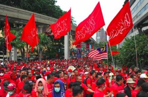 STANDING BY THE LEADER  Supporters of the “Himpunan Maruah Melayu”, meaning Malay Dignity Uprising - the name of the rally, carry flags during a pro-government demonstration in Kuala Lumpur on September 16. Thousands of ruling-party supporters marched through Malaysia’s capital to support the embattled government and assert the political dominance of the Malay majority, in a demonstration whose racial overtones have sparked concern. AFP PHOTO