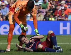 Barcelona’s Argentinian forward Lionel Messi (bottom) complains after being injured next to Las Palmas’ goalkeeper Javi Varas during the Spanish league football match FC Barcelona v UD Las Palmas at the Camp Nou stadium in Barcelona on Sunday. AFP PHOTO