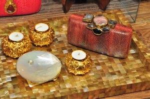 Beauties from the sea in this Mother of Pearl dish and candles with golden sea urchin holders; the clutch on the right is made from snakeskin material featuring local tribal touches