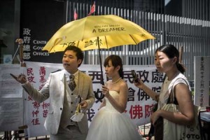 SYMPATHETIC  A recently married couple get ready to take a picture outside the government headquarters building to mark one year since the start of mass pro-democracy rallies calling for fully free leadership elections in the semi-autonomous city, in Hong Kong on Monday. AFP PHOTO