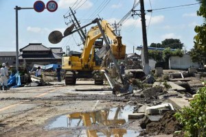 CLEANING UP  A heavy digger is used to remove debris along a damaged road in the city of Joso in Ibaraki prefecture on September 11. Thousands of rescuers arrived in a deluged city north of Tokyo to help evacuate hundreds of trapped residents and search for 12 people missing after torrential rains triggered massive flooding. AFP PHOTO 