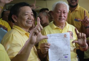 TRY AGAIN Alfredo Lim, popularly called “Dirty Harry,” holds up his certificate of candidacy for mayor of Manila outside the Commission on Elections offices in the city on Tuesday. He denies that he left the city bankrupt when now-Mayor Joseph Estrada succeeded him in 2013. PHOTO BY RENE H. DILAN he 