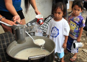 SHE’S GOT THE LOOK Children wait for their turn to be served during a feeding program conducted by the urban poor group, Kadamay, in Barangay Payatas in Quezon city. Photo by Mike De Juan 