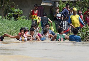 WE WILL SURVIVE Residents of Barangay Pasig in Candaba town in Pampanga tread chest-deep flood. PHOTOS BY RUSSELL PALMA 