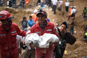 LOST LIFE  A rescuer carries the lifeless body of a child recovered from the mud and debris after a landslide late Thursday (Friday in Manila), following heavy rains, covered part of the village of El Cam