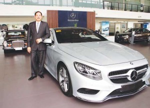 Rene Nuñez stands beside one of the latest models of Mercedes Benz. In the background is his 1969 280 SE that gets a lot of attention from visitors of the CAT Motors showroom along EDSA.
