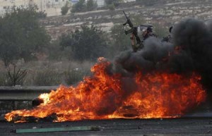 STREET FIRES  Israeli security forces stand behind burning tires during clashes with Palestinians in Beit El, near the West Bank city of Ramallah on Saturday. AFP PHOTO