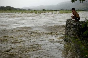A man looks at the swirling, rising water of the Magat River in rain-drenched Nueva Vizcaya. AFP PHOTO