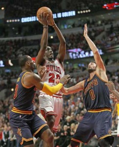 CLEAR SHOT Tony Snell no.20 of the Chicago Bulls puts up a shot between LeBron James no.23 and Kevin Love no.0 of the Cleveland Cavaliers during the season opening game at the United Center on October 27, 2015 in Chicago, Illinois. AFP PHOTO