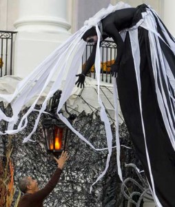 TRICKS AND TREATS  President Barack Obama tries to reach for a performer dancing above him as he hands out treats to children trick-or-treating for Halloween on the South Lawn of the White House in Washington, DC. AFP PHOTO