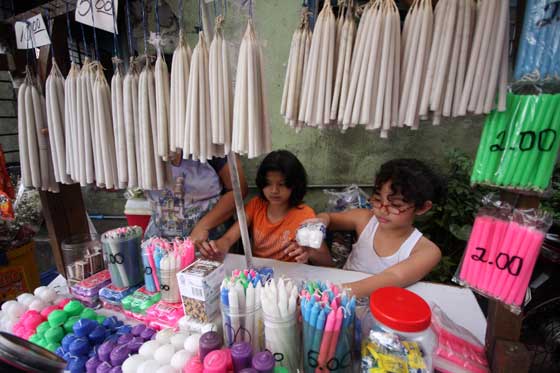 Children sell candles near a cemetery in Marikina City a week before the country remembers its departed. The Department of Trade and Industry is monitoring the prices of candles, a hot commodity as the observance of All Saint Day and All Soul Day approach. PHOTO BY MIGUEL DE GUZMAN