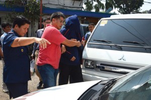 OUT OF THE COUNTRY  Police escort one of the Chinese diplomats suspected of involvement in the shooting of Chinese consular officials to a vehicle in Cebu City. AFP Photo 