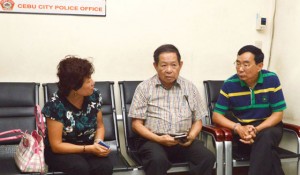 UNDER INVESTIGATION Two Chinese nationals, a consular officer (left) and her husband (right, with handcuffs), suspects in the shooting of Chinese consul general Song Ronghua at a restaurant, talk to an interpreter at a police station in Cebu City. AFP PHOTO 