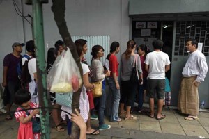 EARLY VOTERS  An official (R) stands outside the Myanmar embassy as Myanmar nationals living in Thailand queue up before casting their vote for the November 8 election, in Bangkok on October 17. AFP PHOTO