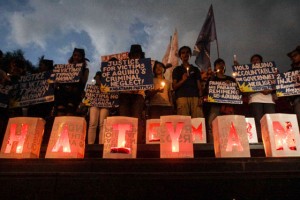 NOVEMBER STORM Activists with lit candles raise their placards to mark the second anniversary of the onslaught of super Typhoon Yolanda (haiyan) at the Liwasang Bonifacio in Manila on Saturday. Photo By DJ Diosina