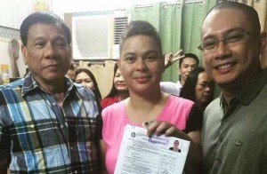 THE BIG SWITCH Former Davao City Mayor Inday Sara Duterte-Carpio is flanked by her father, Mayor Rodrigo Duterte (left) and husband Mans Carpio as she shows off her stamped certificate of candidacy for mayor of Davao City. She replaced her father, who also filed his COC for President. PHOTO FROM MANS CARPIO’S FACEBOOK ACCOUNT