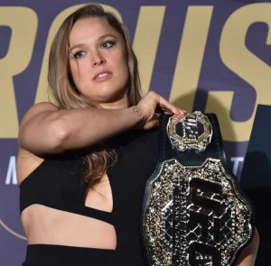 Ronda Rousey of the US picks up her championship belt before a face-off for the UFC fight in Melbourne on Friday. AFP PHOTO