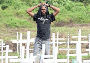 A SEARCH AMONG A SEA OF CROSSES  A man looks for the graveyard of a lost relative at the mass grave for victims of Typhoon ‘Yolanda’ in Tacloban City on Sunday. AFP PHOTO