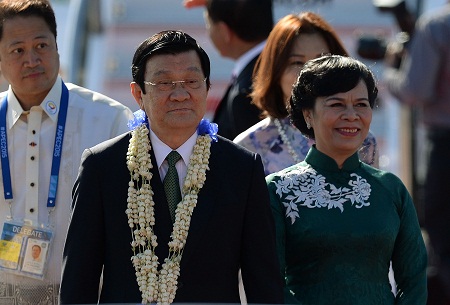 Vietnam's President Truong Tran Sang (2nd L) and his wife Mai Thi Hanh (R) smile upon their arrival at the international airport terminal ahead of the Asia-Pacific Economic Cooperation (APEC) Summit in Manila on November 17, 2015.  Asia-Pacific leaders arrive in the Philippines on November 17 for a summit meant to foster trade unity but with terrorism and territorial rows in focus.   AFP PHOTO / PUNIT PARANJPE
