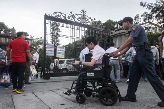 A disabled examinee is wheeled inside the University of Santo Tomas in Manila for the first day of the Bar exams. The Supreme Court said 7,146 law graduates will be taking the tests to be held on four consecutive Sundays. PHOTO BY DJ DIOSINA