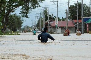 WEATHER DISASTERS ON THE RISE  A picture taken on October 19 shows a resident holding onto a rope as he negotiates a flood current along a submerged highway in Santa Rosa town, Nueva Ecija province, north of Manila, a day after typhoon Koppu (Lando) hit Aurora province. Weather-related disasters have grown more frequent over the last 20 years, claiming more than 600,000 lives, the UN said on November 23, issuing a further call for nations to strike a landmark deal on climate change. AFP PHOTO 