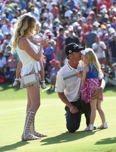 Australia’s Matt Jones kisses his daughter Saber (right) as his wife Melissa (left) and another daughter Savannah look on at the 18th green after Jones won the Australian Open golf tournament in Sydney on Sunday. AFP PHOTO