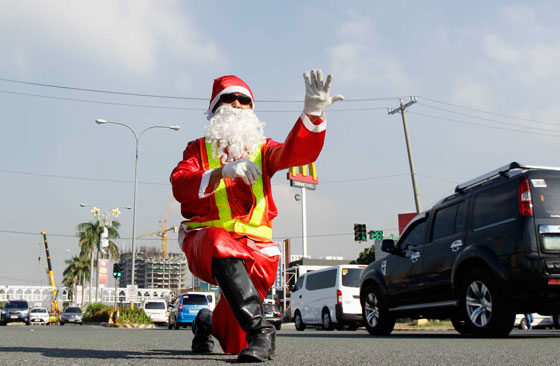 SANTA-RAFFIC ENFORCER  A dancing traffic enforcer dressed in a Santa Claus costume stationed at the Diosdado Macapagal Boulevard in Pasay City reminds motorists and commuters alike that this is supposed be to the happiest season of the year. PHOTO BY CESAR DANCEL