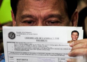 EYE OF THE TIGER Davao City Mayor Rodrigo Duterte playfully hides behind a copy of his certificate of candidacy. 