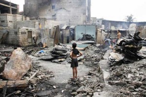 THIS USED TO BE OUR HOME  A boy gazes at the ruins of his home which was among those razed by fire Friday midnight in Barangay Damayang Lagi in Quezon City. Nine people were killed in the inferno.  PHOTO BY MIKE DE JUAN