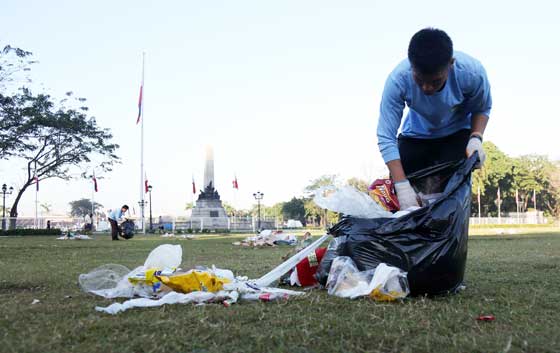 A maintenance staff of the Rizal Park or the luneta in manila hand picks trash that littered metro manila’s only national park. over 600 bags of trash were collected by cleanup crew. PHoto by Russell Palma
