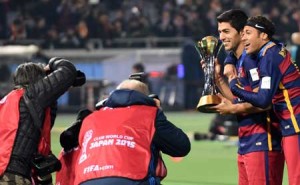 Barcelona forward Luis Suarez (second right) and Neymar (right) hold the FIFA Club World Cup trophy during the awarding ceremony at the Club World Cup football tournament final in Yokohama, suburban Tokyo on Sunday. AFP PHOTO