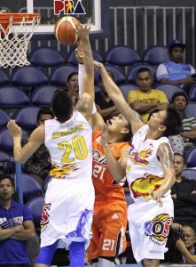 DOUBLE TROUBLE Reynel Hugnatan (No. 21) of Meralco attempts to break through the defense of Raymond Almazan (No.20) and Ronnie Matias (No.33) of Rain or Shine during a PBA Philippines Cup game at the Smart Araneta Coliseum in Quezon City on Wednesday. PHOTO BY CZEASAR DANCEL