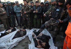 FALLEN  Afghan security personnel stand over the bodies of militants in front of damaged buildings after a car bomb attack near the Spanish embassy compound in Kabul on Saturday. AFP PHOTO