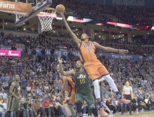 Kevin Durant No.35 of the Oklahoma City Thunder sails past Derrick Favors No.15 of the Utah Jazz for two points during the third period of a NBA game at the Chesapeake Energy Arena on Monday in Oklahoma City, Oklahoma. AFP PHOTO